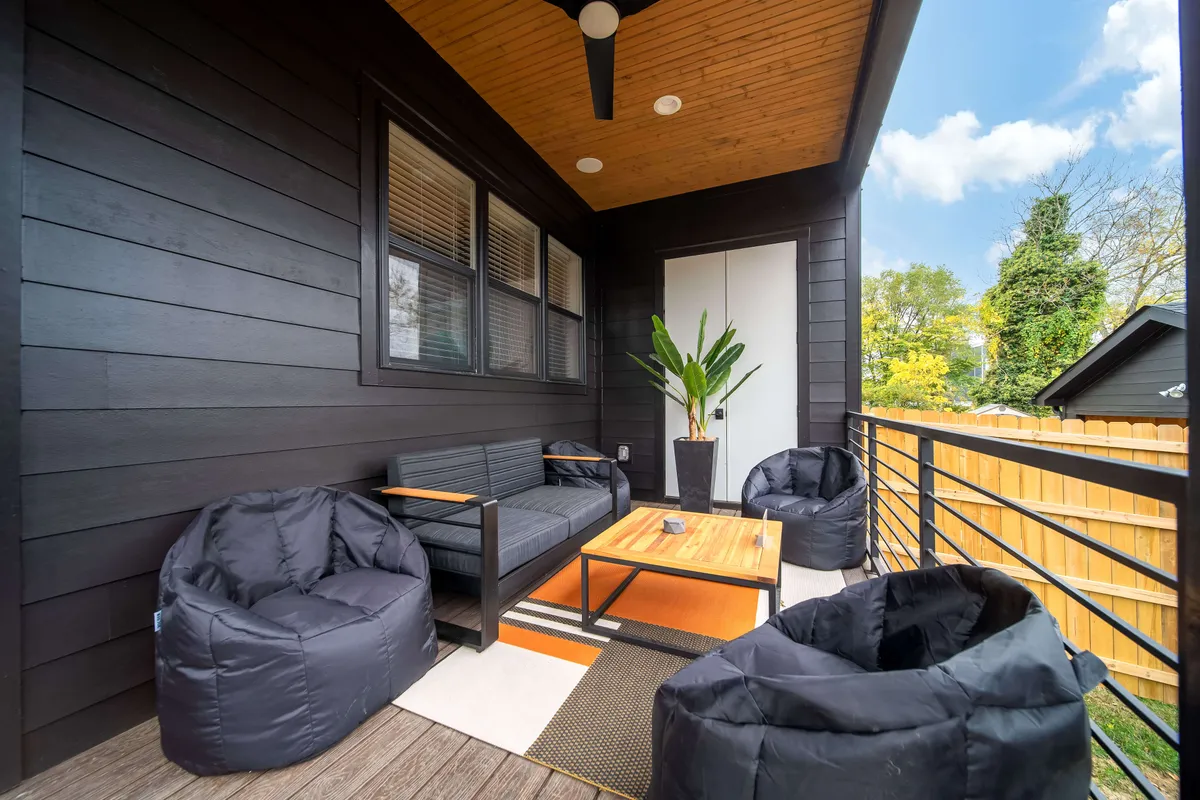 This image depicts a comfortable outdoor seating area complete with a coffee table and potted plant, set in a welcoming exterior environment ideal for relaxation or group gatherings. The space is arranged to invite conversation, sunset viewing, and stargazing, connecting the home to the outside world.