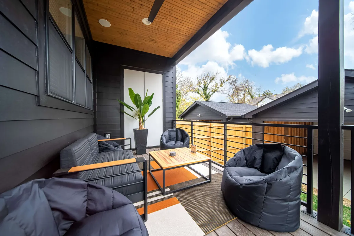 An exterior patio scene featuring stylish, comfortable seating, a greenery-filled planter, and a central coffee table. The arrangement evokes a sense of community and is ideal for both quiet moments and lively group celebrations. The space is bathed in natural light, reinforcing the connection between indoor comfort and the vibrant world outside.